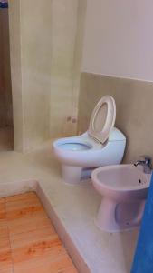 Silver Rock Hotel في ماليندي: حمام مع مرحاض وشطاف