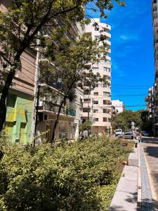 una calle de la ciudad con un edificio alto y arbustos en Departamento en Villa Crespo en Buenos Aires