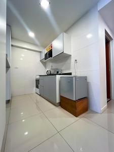 Luminoso departamento en Villa Crespo في بوينس آيرس: مطبخ بجدران بيضاء واجهزة بيضاء