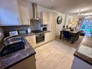 a kitchen with a sink and a dining room with a table at 4BR Cheshire East/Townhouse/Central - Close to Bentley in Crewe