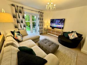 a living room with a couch and a flat screen tv at 4BR Cheshire East/Townhouse/Central - Close to Bentley in Crewe