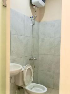 y baño con aseo y lavamanos. en Kelud Syariah Guesthouse, en Blitar