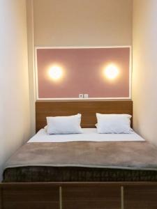 1 dormitorio con 1 cama con 2 almohadas en Kelud Syariah Guesthouse, en Blitar