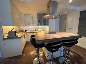 una cocina con una isla de madera con taburetes de bar en Appartement Saint Tropez, en Saint-Tropez