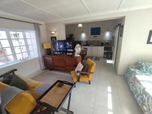 a living room with a couch and a tv at Paradise in the City - Cottage One in Port Elizabeth