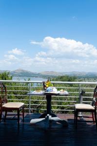 a table and chairs on a balcony with a view of the water at 129inHarties Lodge and SPA in Hartbeespoort