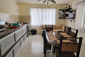 a kitchen with a table and chairs and a couch at Quinta Paraiso Presa de la boca in Santiago