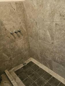 a bathroom with a shower with a tiled floor at Quinta Paraiso Presa de la boca in Santiago