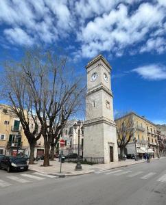 una torre del reloj al lado de una calle en Casa l'Orologio, en Barletta