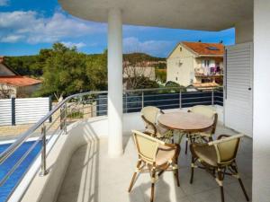 eine Terrasse mit einem Tisch und Stühlen auf dem Balkon in der Unterkunft Nice apartment -with new private pool in Stari Grad