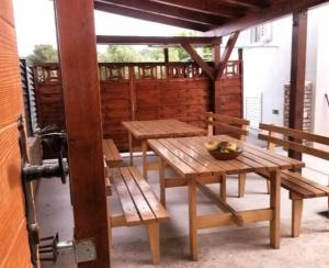 einen Holztisch und Bänke auf einer Terrasse in der Unterkunft Nice apartment -with new private pool in Stari Grad