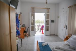 ein Schlafzimmer mit einem Bett und ein Zimmer mit einem Tisch in der Unterkunft Pension St.George Rooms & Studios in Perivolos