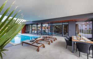 a house with a pool and a table and chairs at Villa Grande Arche Istria in Ližnjan