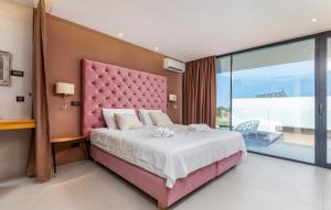 a pink bedroom with a large bed with a pink headboard at Villa Grande Arche Istria in Ližnjan