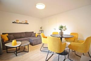 a living room with a couch and a table and chairs at Blossfeld-Apartments XL-Ferienwohnung Jena Zentrum, 2 Schlafzimmer, W-Lan, Waschtrockner, Smart-TV in Jena