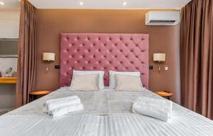 a bedroom with a large bed with a pink headboard at Villa Grande Arche Istria in Ližnjan