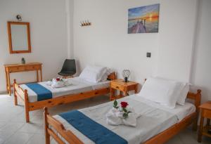 a bedroom with two beds and a picture on the wall at Pension St.George Rooms & Studios in Perivolos