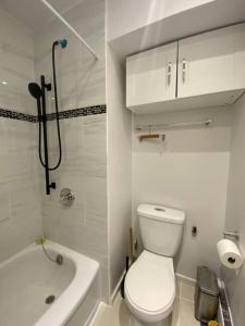 Un baño blanco con inodoro y bañera. en Great natural light Apartment in Historic Building, en Grimsby 27 fotos más