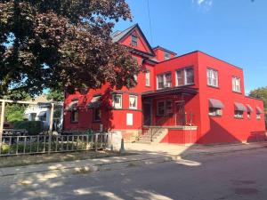 una casa roja con una valla delante en Great natural light Apartment in Historic Building, en Grimsby