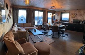 ein Wohnzimmer mit einem Sofa und einem Tisch in der Unterkunft Flott moderne hytte i Holterdalen, 4 soverom, 2 bad, Jacuzzi, garasje in Rauland