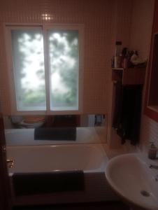a bathroom with a tub and a sink and a window at Valarya in Cercedilla