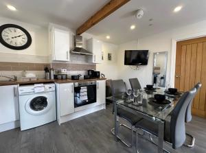 a kitchen with a table and a clock on the wall at Cardiff Retreat with Private Garden! Perfect for Contractors, Tourists, Relocators in Cardiff