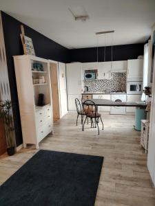 eine Küche mit einem Tisch und Stühlen im Zimmer in der Unterkunft Joli appartement sur la côte in Saint-Jean-le-Thomas