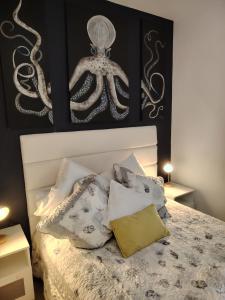 ein Schlafzimmer mit einem Oktopus-Gemälde an der Wand in der Unterkunft Joli appartement sur la côte in Saint-Jean-le-Thomas