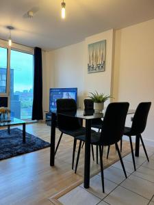 comedor con mesa, sillas y TV en Spacious 2 Bedrooms Apartment In Stratford en Londres