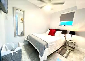 ein Schlafzimmer mit einem Bett mit roten Kissen in der Unterkunft Little Gables Studio-Your Miami Escape-10min Airport in Miami