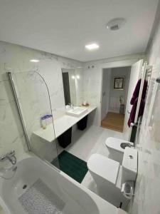 a bathroom with a sink and a toilet and a tub at preciosa casa,garage wifi 4 personas in Vigo