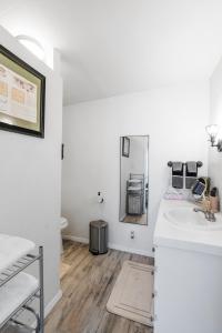 La salle de bains blanche est pourvue d'un lavabo et d'un miroir. dans l'établissement Private Joshua Tree Cabin w/ Hammocks & Campfire, à Yucca Valley