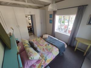 a small room with a bed and a window at Paradise in the City - Cottage One in Port Elizabeth