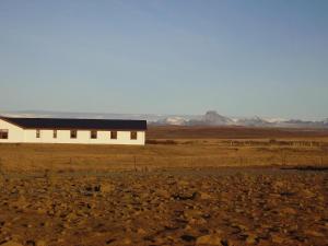 セールフォスにあるMyrkholt Cabinの山々を背景にした砂漠の中の建物