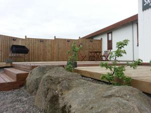 a backyard with a wooden deck and a fence at Myrkholt Cabin in Selfoss