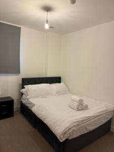 1 dormitorio con 1 cama con sábanas y almohadas blancas en Spacious 2 Bedrooms Apartment In Stratford, en Londres
