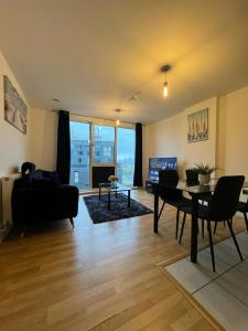 a living room with a table and a couch at Spacious 2 Bedrooms Apartment In Stratford in London