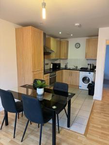 a kitchen with a dining room table and chairs at Spacious 2 Bedrooms Apartment In Stratford in London
