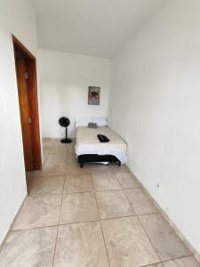 a bedroom with a bed and a tiled floor at Loft Famíliar Br/Aeroporto 22 in Uberlândia