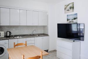 uma cozinha com armários brancos e uma mesa de madeira em Apartamento Sol y Mar em San Bartolomé