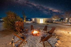 - un foyer extérieur de nuit avec des chaises et un foyer sidx sidx sidx dans l'établissement Private Joshua Tree Cabin w/ Hammocks & Campfire, à Yucca Valley