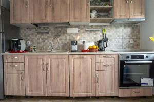 a kitchen with wooden cabinets and a sink at Pensiunea MATRIOSKA in Jurilovca