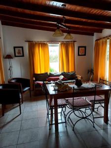 sala de estar con mesa de madera y sillas en Soñada en Tandil