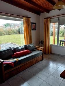 ein Wohnzimmer mit einem Sofa und einem großen Fenster in der Unterkunft Soñada in Tandil