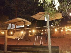 a grill with an umbrella and a bbq grill at MEYAHUALLI GLAMPING in Huasca de Ocampo