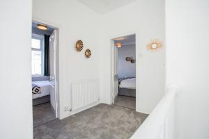 um quarto branco com uma cama e uma janela em West Beck House - Newcastle 5 em North Shields