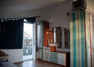 a room with a kitchen with a sink and a window at вила Лора in Sinemorets