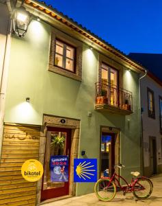 a red bike parked in front of a building at Olá Vida - Hostel Caminha in Caminha