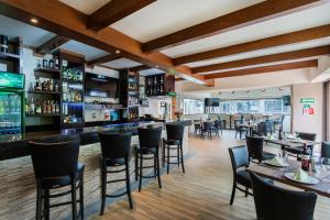 a restaurant with tables and chairs and a bar at Comfort Inn Puebla Centro Hist rico in Puebla