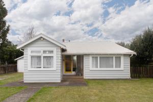 una pequeña casa blanca con patio en Devon Eleven en Rotorua
